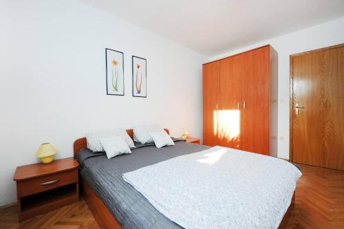 a bedroom with a large bed and a wooden cabinet at Olea Apartments in Srima