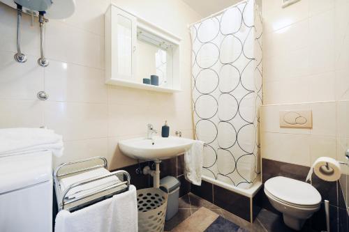 a bathroom with a sink and a toilet at Olea Apartments in Srima