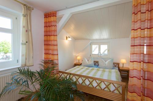 un dormitorio con una cama y una ventana en Haus Rosengarten, en Middelhagen