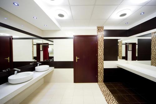 łazienka z 2 umywalkami i 2 toaletami w obiekcie Hotel Centrum w mieście Kwidzyn