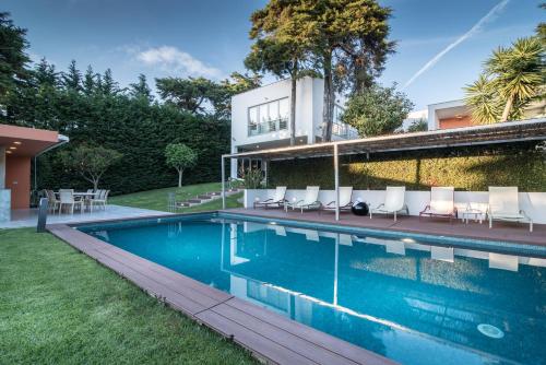 a house with a swimming pool with chairs and a building at Cascais Casa Laranja Boutique House in Cascais
