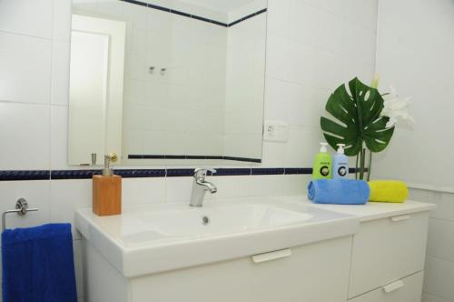 y baño con lavabo blanco y espejo. en Apartamento 2 dormitorios muy centrico, en Jerez de la Frontera