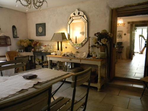 Cette chambre comprend une table et un miroir mural. dans l'établissement La Grange à Nicolas, à Baume-les-Messieurs