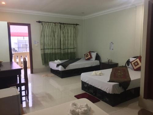 a hotel room with two beds and a balcony at IKI IKI Guesthouse in Siem Reap