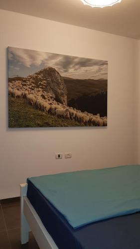 a painting of a herd of sheep on a wall at Beautiful Apartment on The First Line of The Sea in Haifa