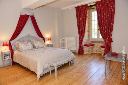 Chateau de Balleure في Étrigny: غرفة نوم بسرير كبير مع ستائر حمراء