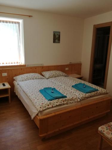 a bedroom with a bed with blue napkins on it at B&B El Molin in Cavalese