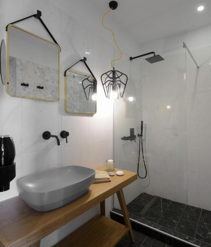 a bathroom with a tub and a shower with a mirror at Castristudios in Nikiti