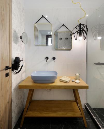 a bathroom with a blue sink on a wooden table at Castristudios in Nikiti