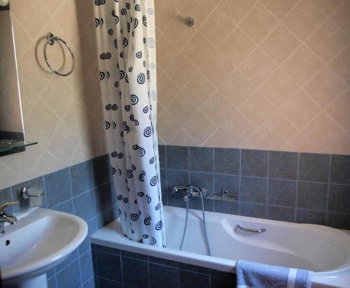 a bathroom with a bath tub and a sink at Hotel Theasi in Diakopto