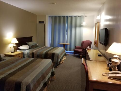 a hotel room with two beds and a desk at Knights Inn Woodstock in Woodstock