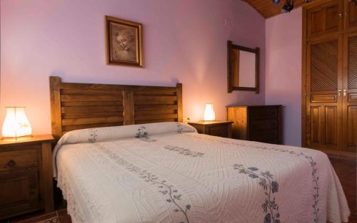 um quarto com uma cama grande e 2 candeeiros em Vivienda de Uso Turístico La Atalaya em El Barco de Ávila