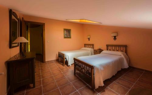 um quarto de hotel com duas camas e uma televisão em Vivienda de Uso Turístico La Atalaya em El Barco de Ávila