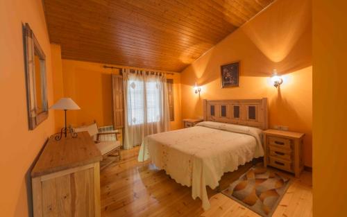 um quarto com uma cama grande e um tecto de madeira em Vivienda de Uso Turístico La Atalaya em El Barco de Ávila