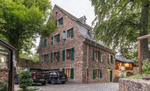 a brick house with cars parked in front of it at Schloss Auerbach Große Ferienwohnung in Bensheim