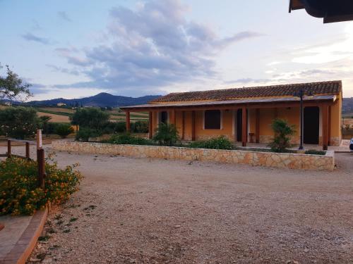 a house with a gravel driveway in front of it at Agriturismo l'Olivo in Calatafimi