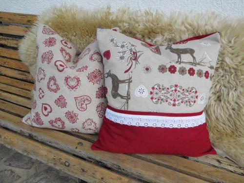 two pillows are sitting on a wooden bench at Thoamlhof in Leutasch