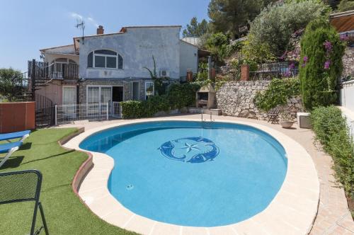 a large blue swimming pool in front of a house at Pedraviva in Ador