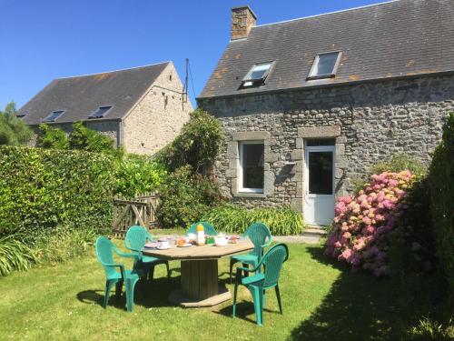 a table and chairs in the yard of a house at Le Pressoir de la Gervaiserie - 300m de la plage in Réville
