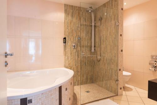 La salle de bains est pourvue d'une baignoire et d'une douche. dans l'établissement Hotel Central, à Bad Mergentheim
