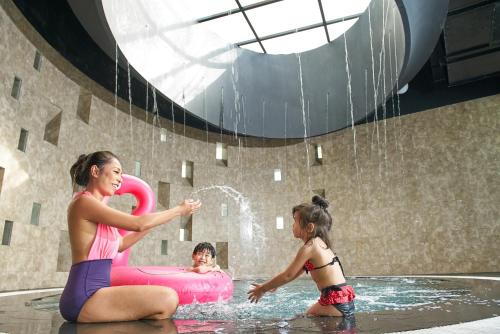 a woman and a man in a swimming pool at Grand Ion Delemen Hotel in Genting Highlands