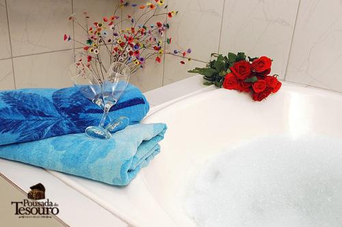 un bagno con lavandino e vaso con fiori di Pousada do Tesouro a Parati