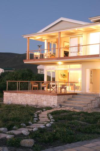 a large house with a porch and a patio at 138 Marine Beachfront Guesthouse in Hermanus