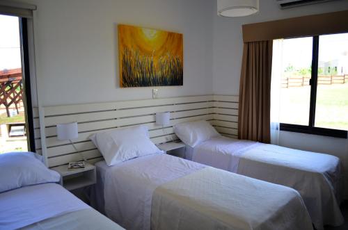 a room with three beds and a painting on the wall at Rio y Piedras in Colón