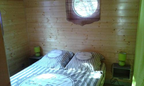 Habitación pequeña con cama y ventana en roulotte en Cournonterral