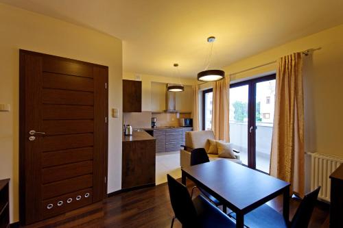 a living room with a table and a kitchen at Foka, Sun & Snow in Hel