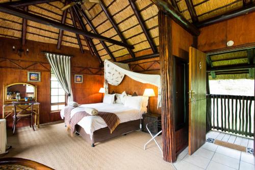 a bedroom with a bed in a wooden room at iNsingizi Lodge in Mid Illovo
