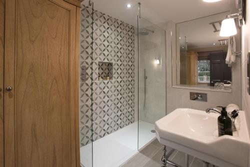 a bathroom with a glass shower and a sink at Saltmarshe Hall in Saltmarshe