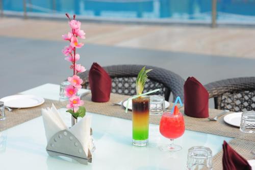 una mesa con un juego de mesa para una comida con una bebida en Hotel Sea N Rock, en Thane