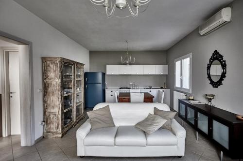 a bedroom with a white bed and a white couch at Rouge Hotel International in Milano Marittima