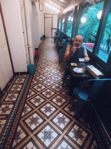 a man sitting at a table in a restaurant at Carlton Hotel Mumbai - Behind Taj Mahal Palace Colaba Mumbai in Mumbai