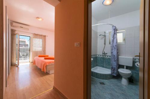 ein Bad mit einem Bett, einer Badewanne und einem WC in der Unterkunft Apartment "San Marino" in Baška Voda