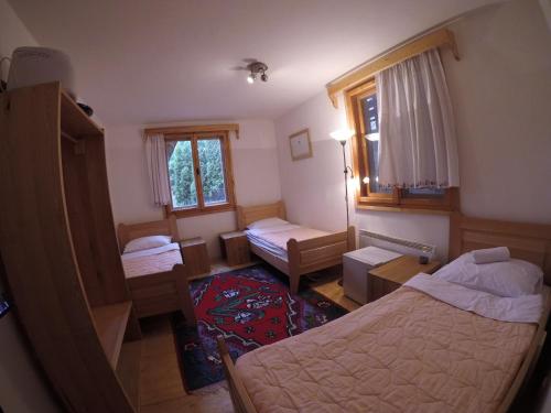 um pequeno quarto com 2 camas e um quarto com 2 janelas em Etno kutak Prijepolje em Prijepolje
