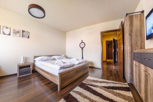 a bedroom with a bed and a clock on the wall at Foka, Sun & Snow in Hel