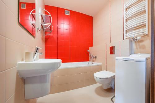 a bathroom with a white toilet and a red wall at Foka, Sun & Snow in Hel