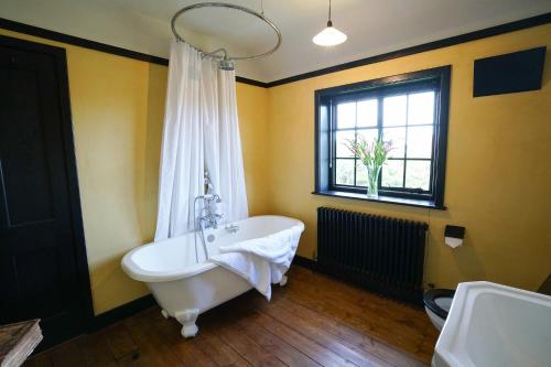 a bathroom with a white bath tub and a window at The Vintage House, Aldeburgh in Aldeburgh