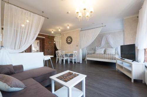 a living room with a couch and a tv at Hotel Gogol House in Saint Petersburg