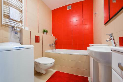 a bathroom with a toilet and a tub and a sink at Foka, Sun & Snow in Hel
