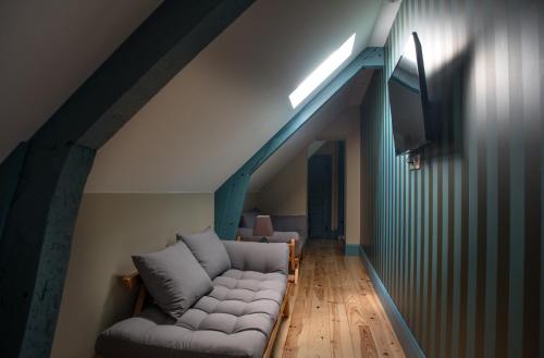 Una sala de estar con un sofá en el ático. en Le Relais, en Bagnères-de-Bigorre