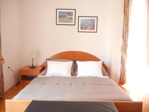 a bedroom with a large bed with two pillows at Villa Laurea in Lovran