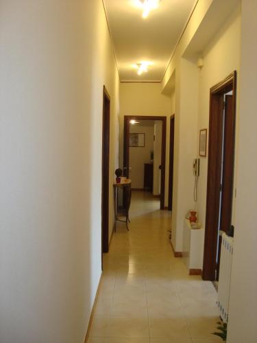 a hallway with white walls and a tile floor at Casa delle Pomelie - Taormina & Etna Panoramic Views in Riposto