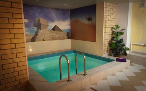 a swimming pool in a bathroom with a painting on the wall at Hotel Abazhur-ZURO in Ulyanovsk