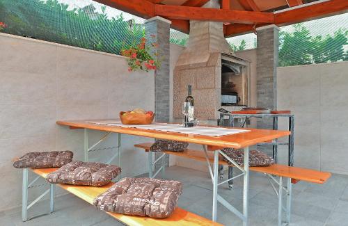 een patio met een tafel en banken en een keuken bij Apartments Denis 344 in Fažana