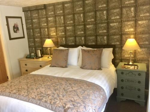 a bedroom with a bed with two lamps and two night stands at The Swan Inn in Nantwich