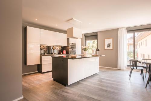 a kitchen with white cabinets and a table with chairs at Independance First in Interlaken