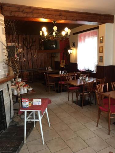 a dining room with tables and chairs and a fireplace at Horský Hotel Arnica in Loučná pod Klínovcem